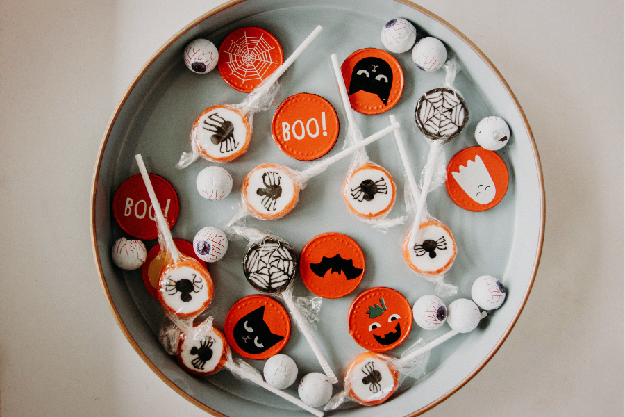A bowl of assorted Halloween candies in black, white, and orange